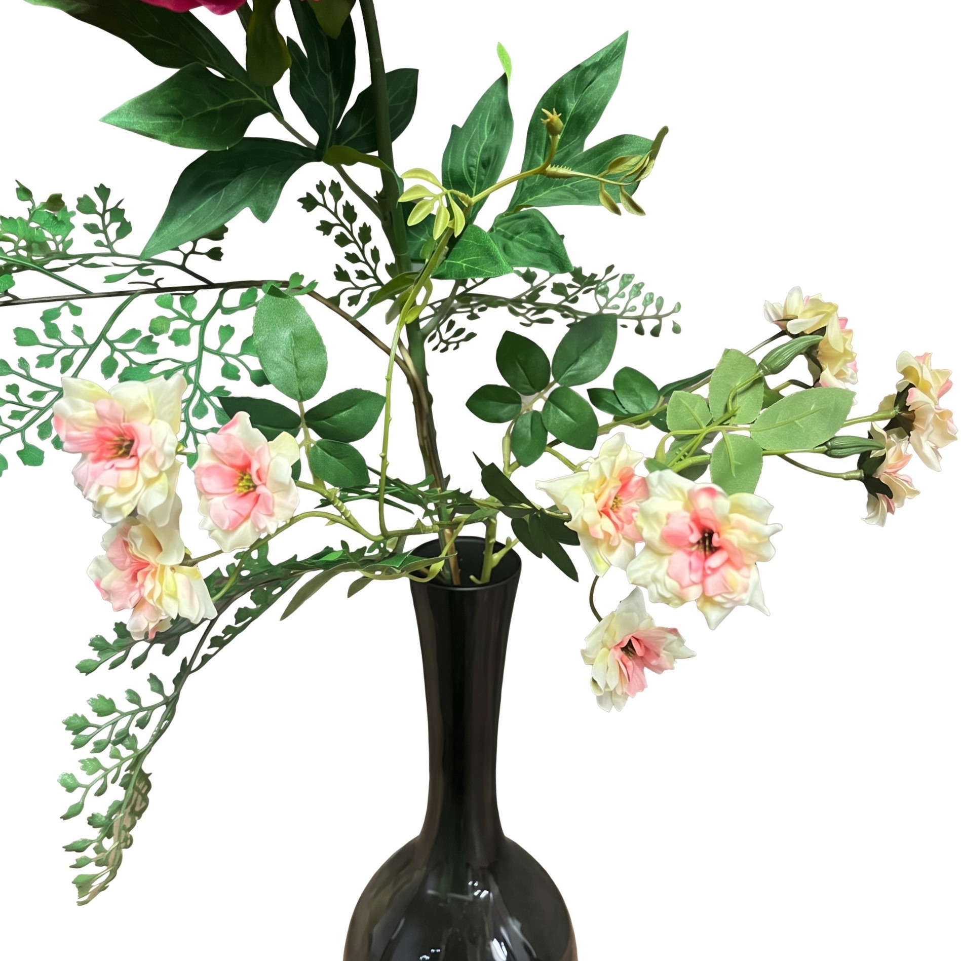 Detail van de kleine zalmroze bloemen en varenachtige bladeren.