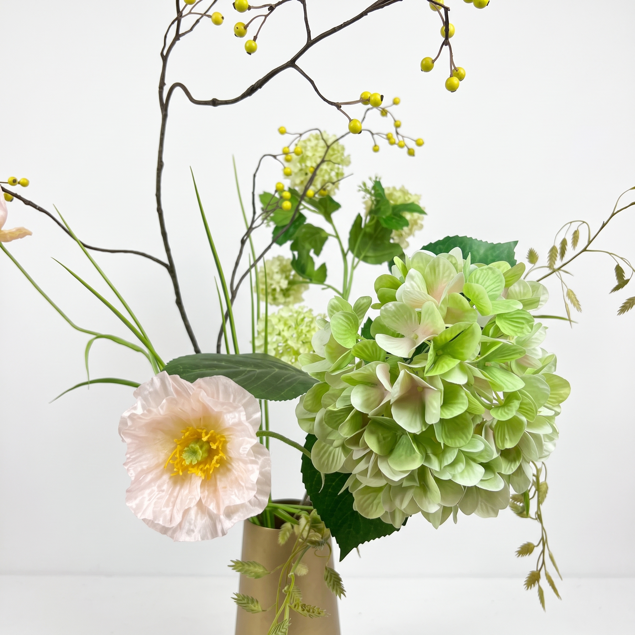 Detailopname van kunstboeket met hortensia en pastelroze klaproos
